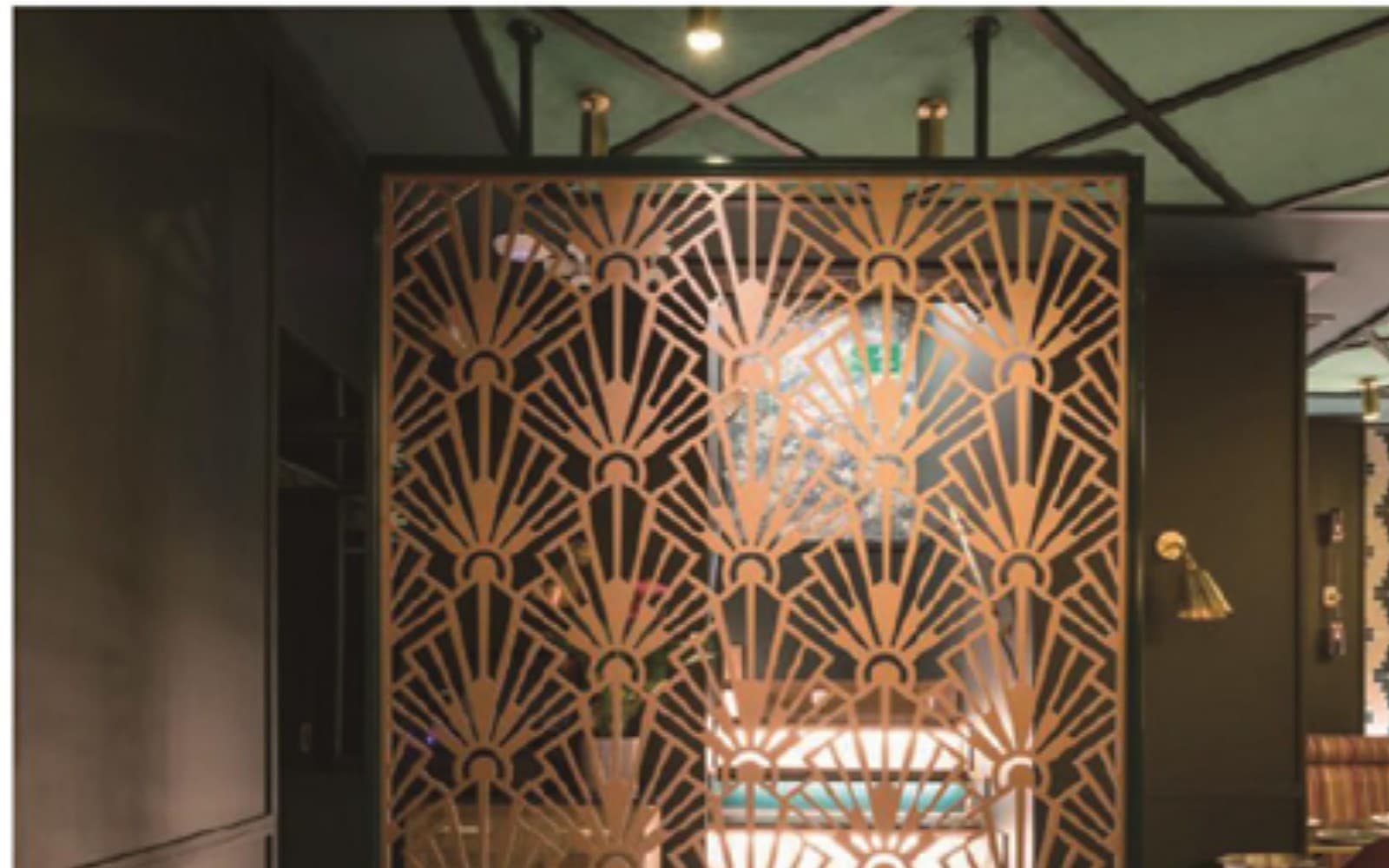 Decorative metal screen with a warm geometric pattern in a commercial interior